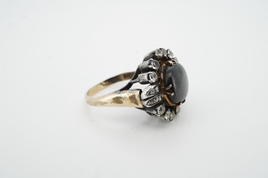 An Indian? yellow and white metal (shank stamped 18k), greyish star sapphire and simulated diamond cluster set dress ring, size O, gross weight 8.2 grams. Condition - poor (stone missing).